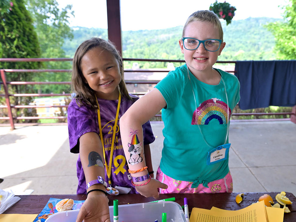 Campers show off their painted designs on their arms at Camp Fantastic.