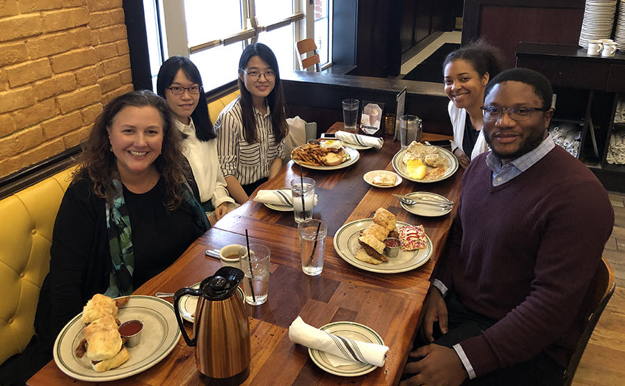 5 people seated around a lunch table.
