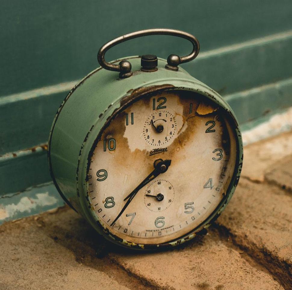 An old green analog clock 