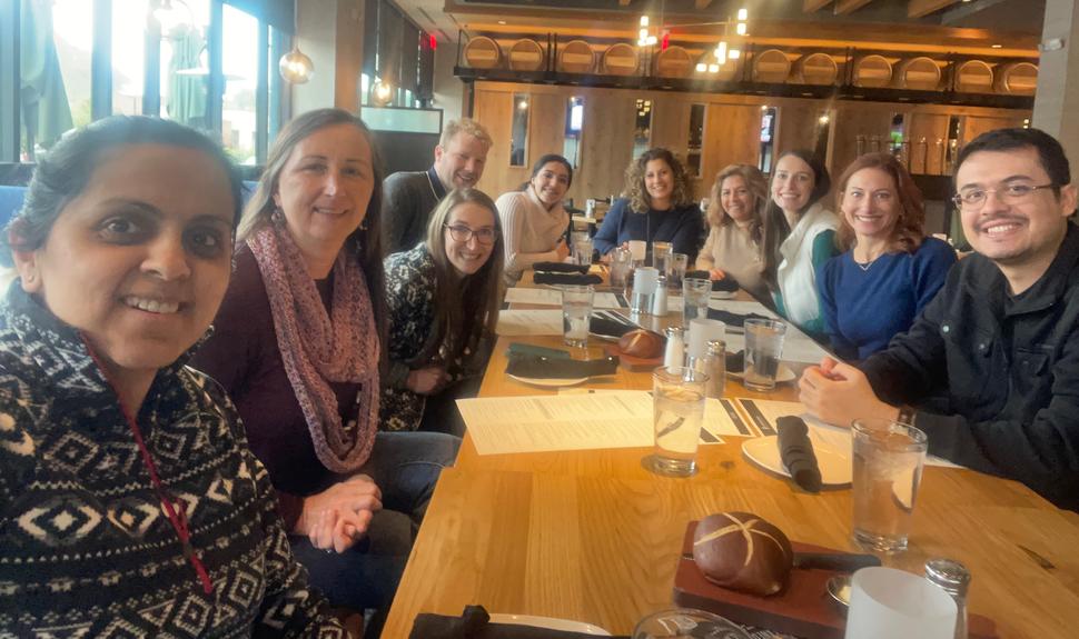 Study team members seated around a table at a restaurant.