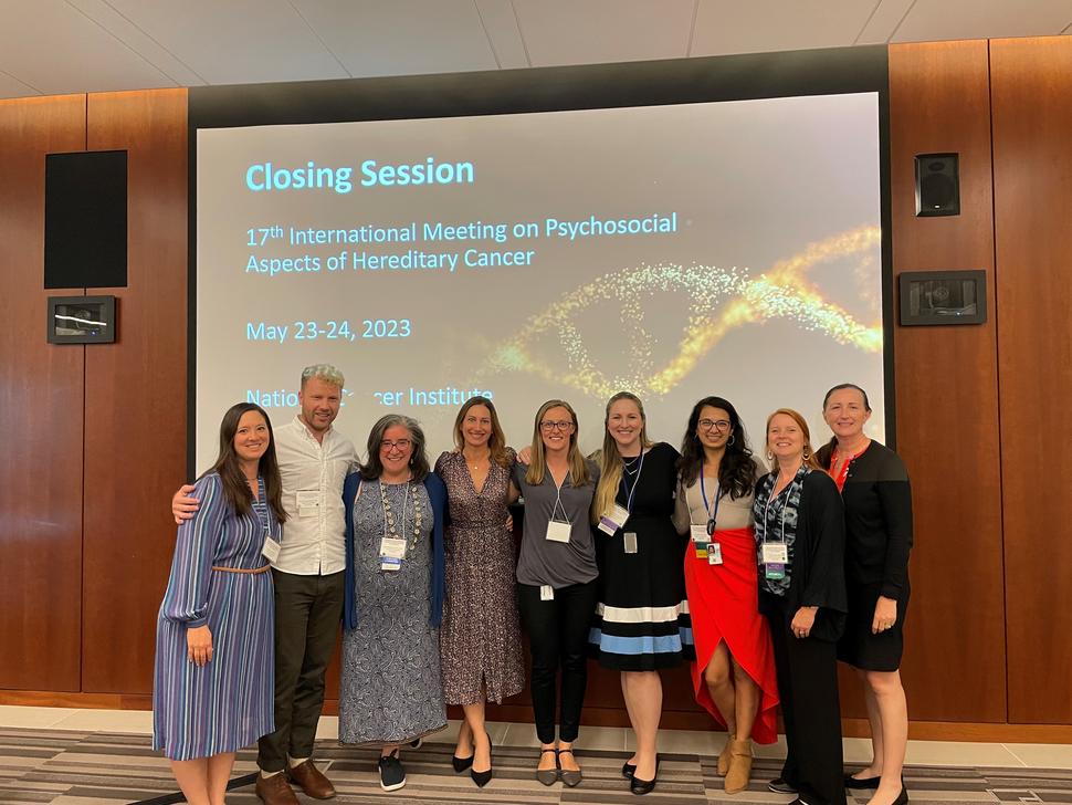 IMPAHC participants stand together in front of Closing Session slide. 