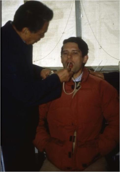 photograph of two men, one undergoing esophageal cytology with a balloon.