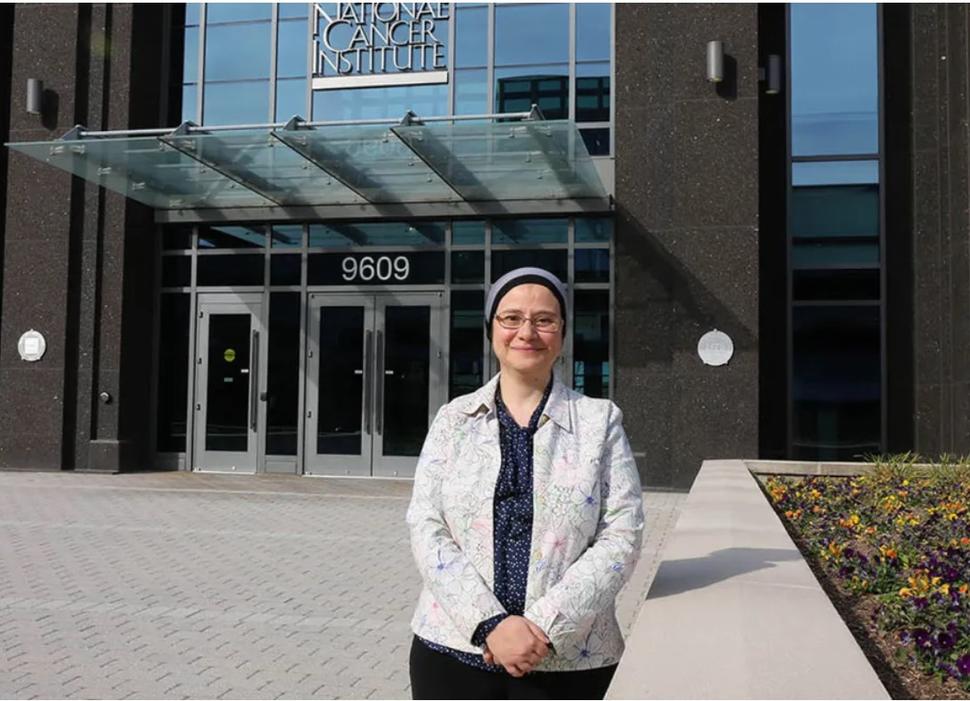 Shahinaz Gadalla in front of NCI building at Shady Grove 