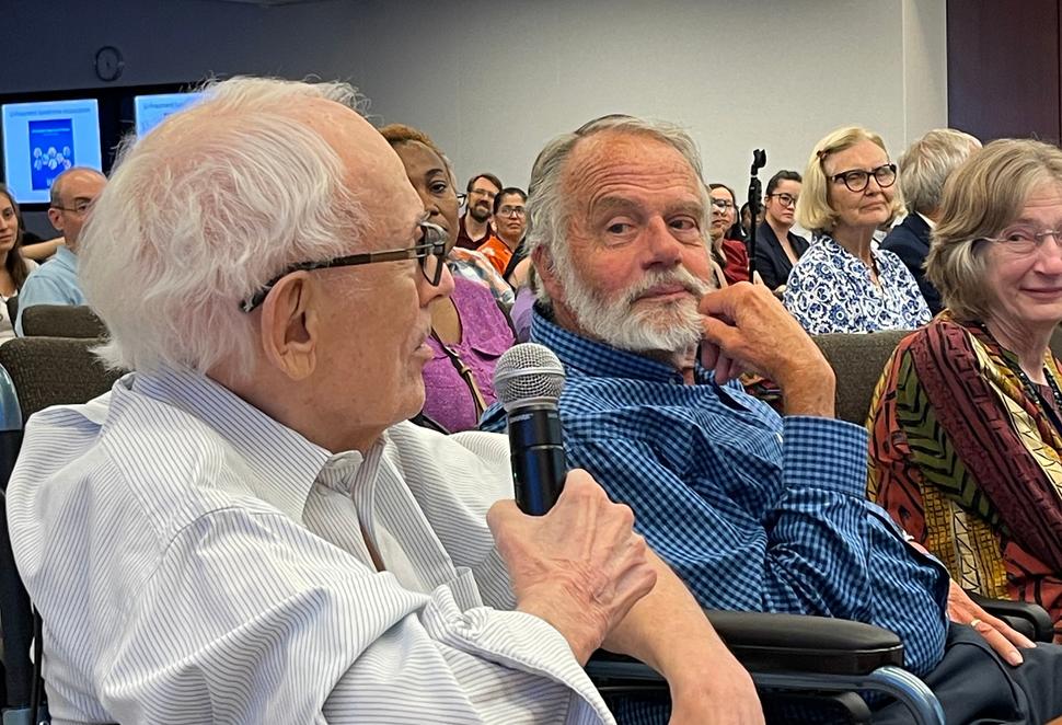 photograph of man with microphone in front of crowd