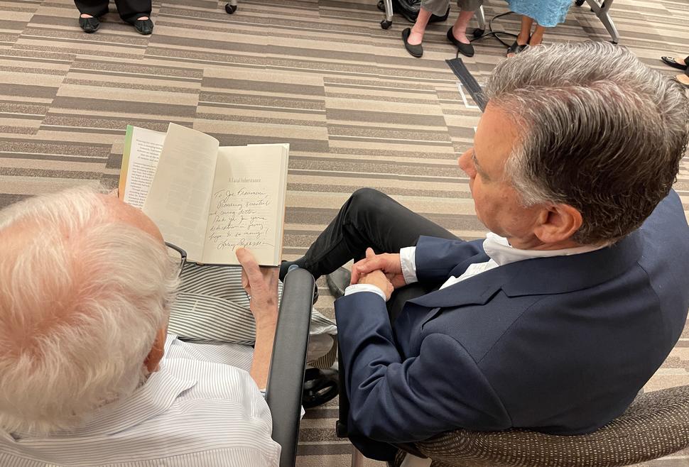 photograph of two men looking at an open book