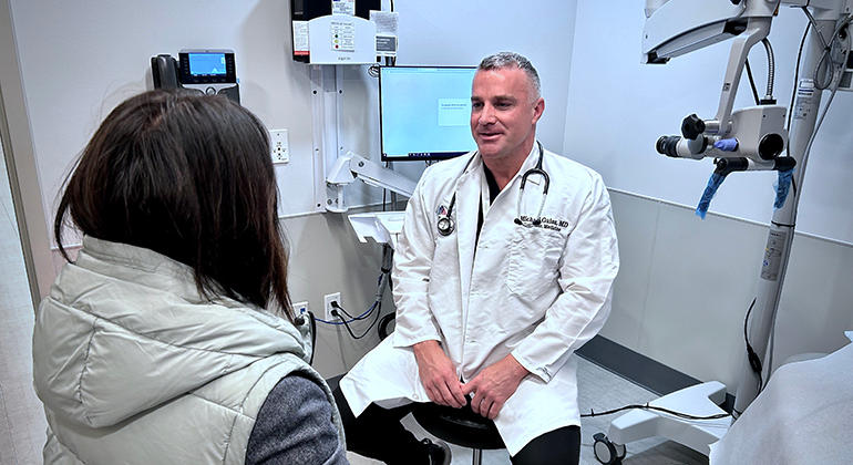 Dr. Michael Gaisa talks to a patient in front of an anoscope.