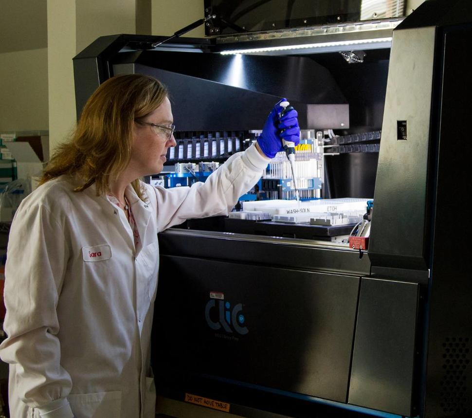 technician loading a machine with research samples