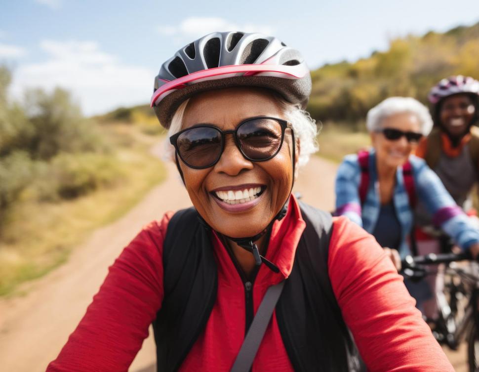 Portrait of happy senior woman in cycling helmet riding outdoors.