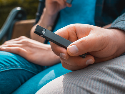 Image of a hand holding an electronic vape pen.