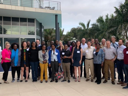 Large group of people smiling and standing outside a building.