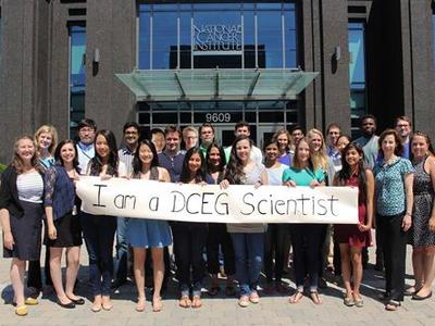 Group of DCEG fellows with banner "I am a DCEG Scientist"