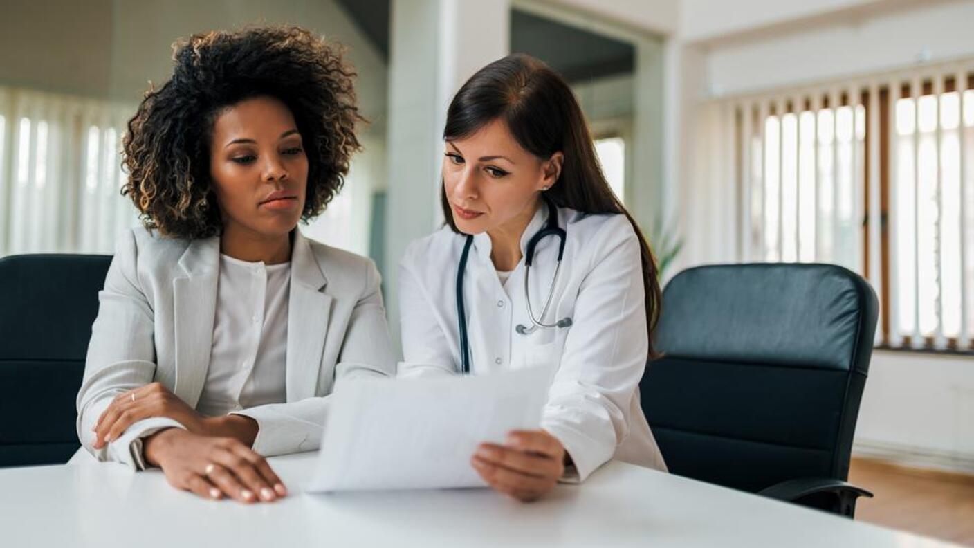A black woman patient reviews results with a doctor.