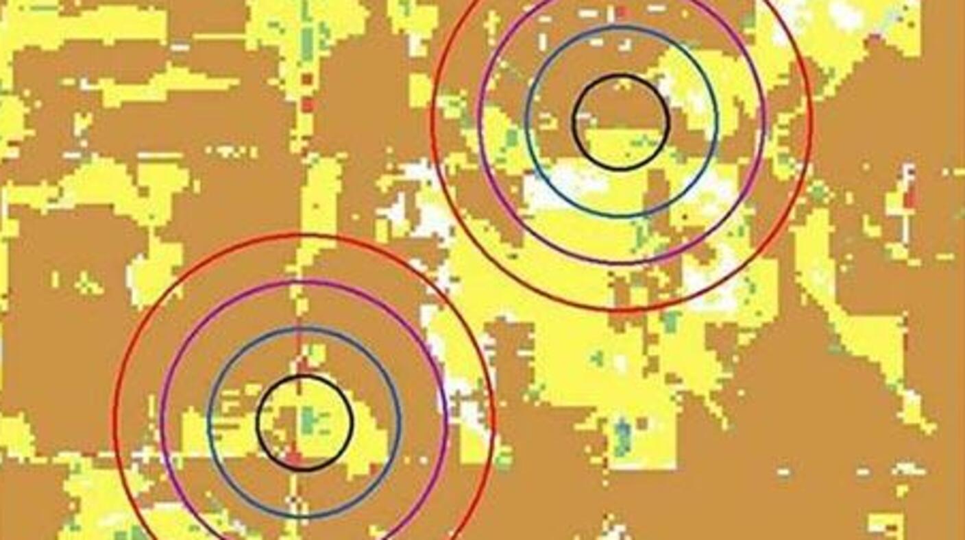 A GIS land usage map displays an agricultural area with two residences whose locations are indicated by concentric circles representing buffer zones of increasing size. 