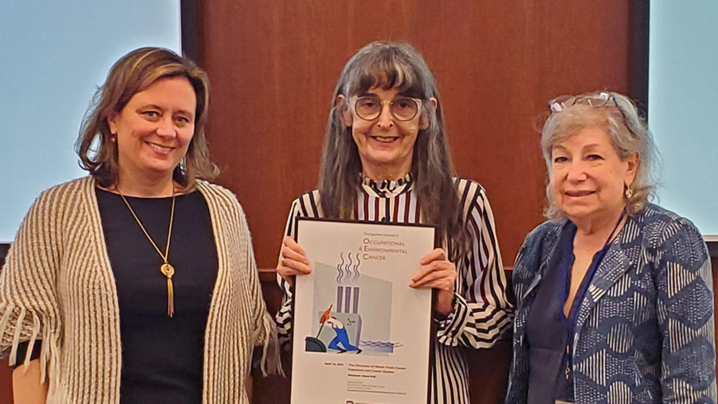 Lecturer Liz Ward receiving a plaque from Laura Beane Freeman and Debra Silverman