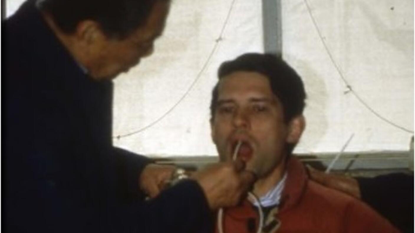 photograph of two men, one undergoing esophageal cytology with a balloon.