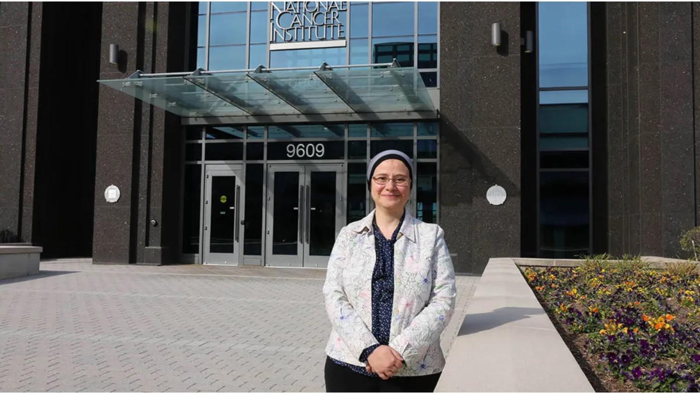 Shahinaz Gadalla in front of NCI building at Shady Grove 