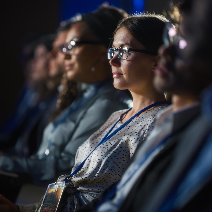 Row of people sitting at a conference.