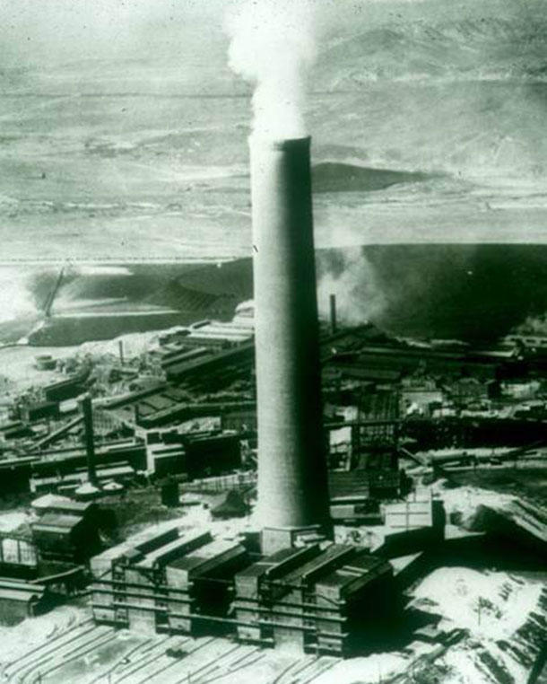 Historical photo of a copper smelter billowing smoke