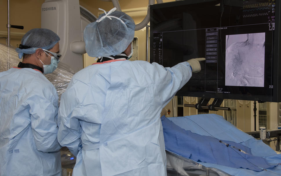 Image of two physicians conducting an fluoroscopically guided interventional procedure.