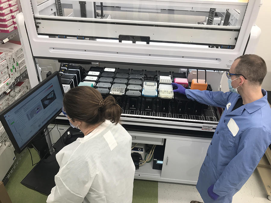 Research assistants on the Genome Discovery Team in CGR perform a desulphonation and cleanup process using an automated work station.