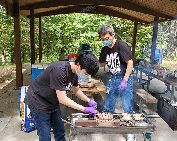Choi Lab members collaborate on turning out kabobs at a branch picnic. 