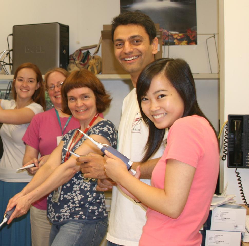 Photo of 5 people holding pipettes and smiling