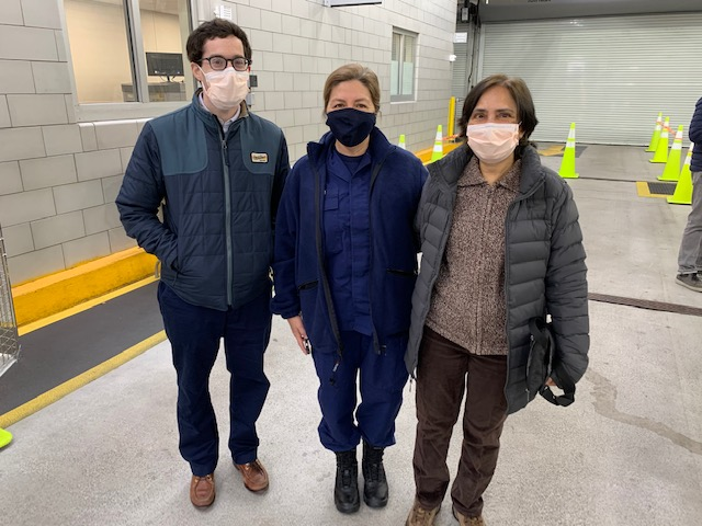 Photo of Sargen, Aryavand, and Giri standing with masks in the COVID testing car line