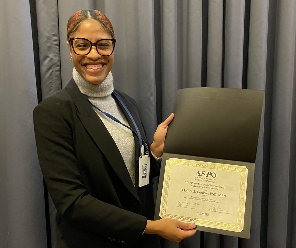 Quiera Booker holds her Outstanding Poster Award from the ASPO Disparities Special Interest Group.