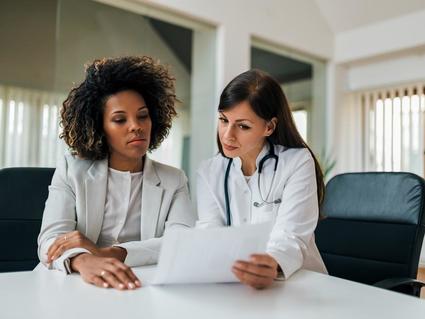 A black woman patient reviews results with a doctor.