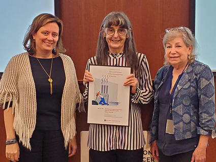 Lecturer Liz Ward receiving a plaque from Laura Beane Freeman and Debra Silverman