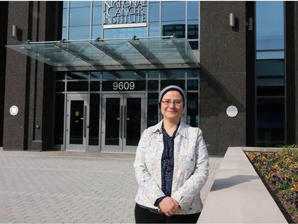 Shahinaz Gadalla in front of NCI building at Shady Grove 