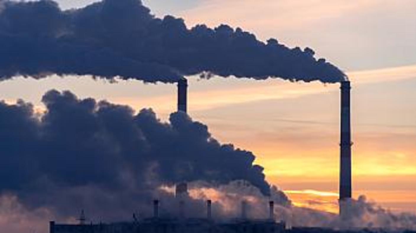 Emission to atmosphere from industrial factory chimney. Smokestack pipes shot with drone. Aerial view.