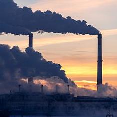 Emission to atmosphere from industrial factory chimney. Smokestack pipes shot with drone. Aerial view.