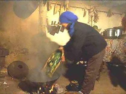 woman cooking in a wok with a lot of smoke